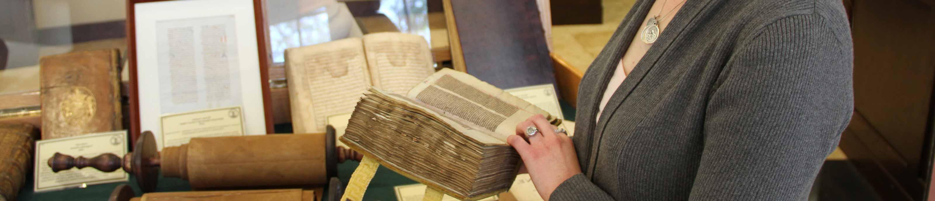 在“时代的智慧”展览中，一名学生正在研究一本古书