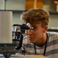 一个学生在实验室里通过目镜看东西