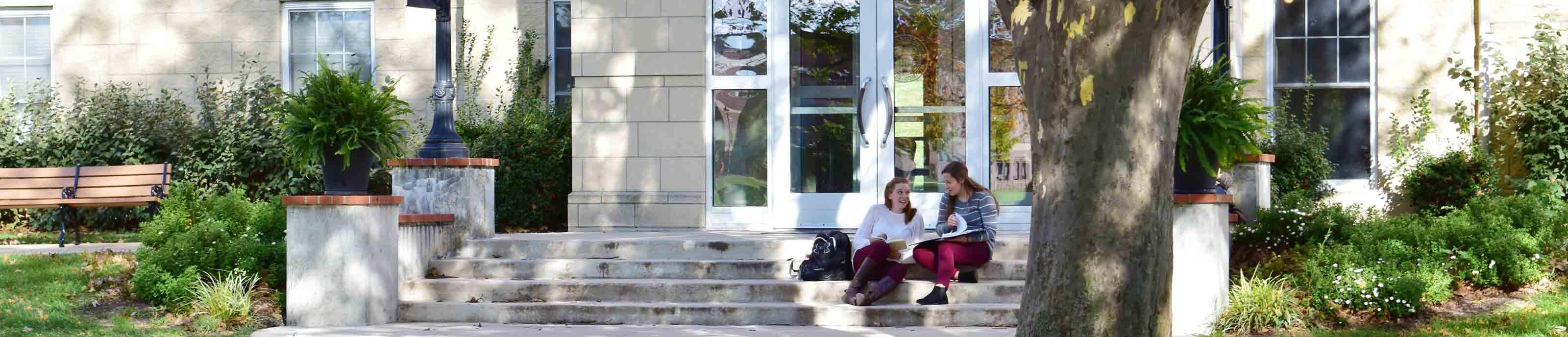 Residents hang out on the steps of St. Scholastica Hall